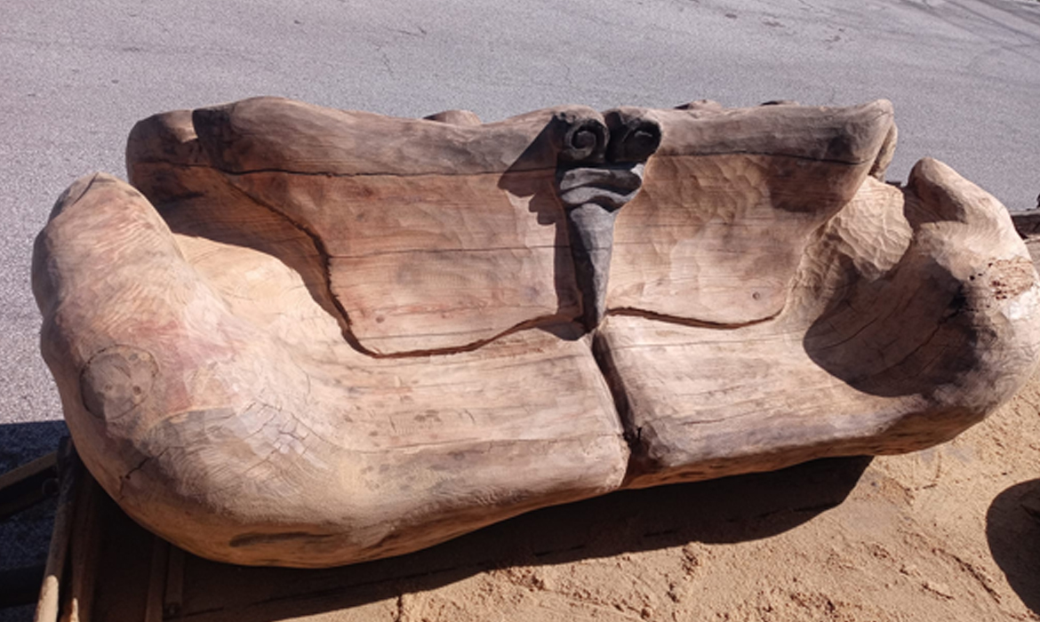 Hands holding a butterfly bench carved by Elvis
                  Caron
