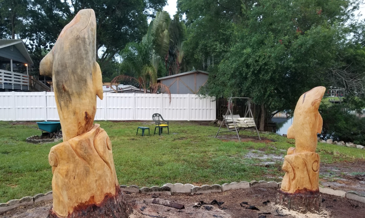 Mommy and Baby Dolphins jumping carved from pine
                trees